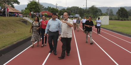 El rector y el director de la Sede del Atlántico caminan sobre la pista de atletismo.